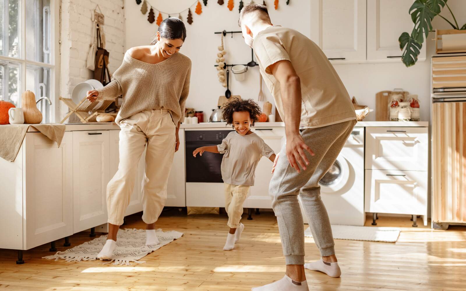 an energetic, healthy family having fun in the kitchen - mom, dad, and their young child