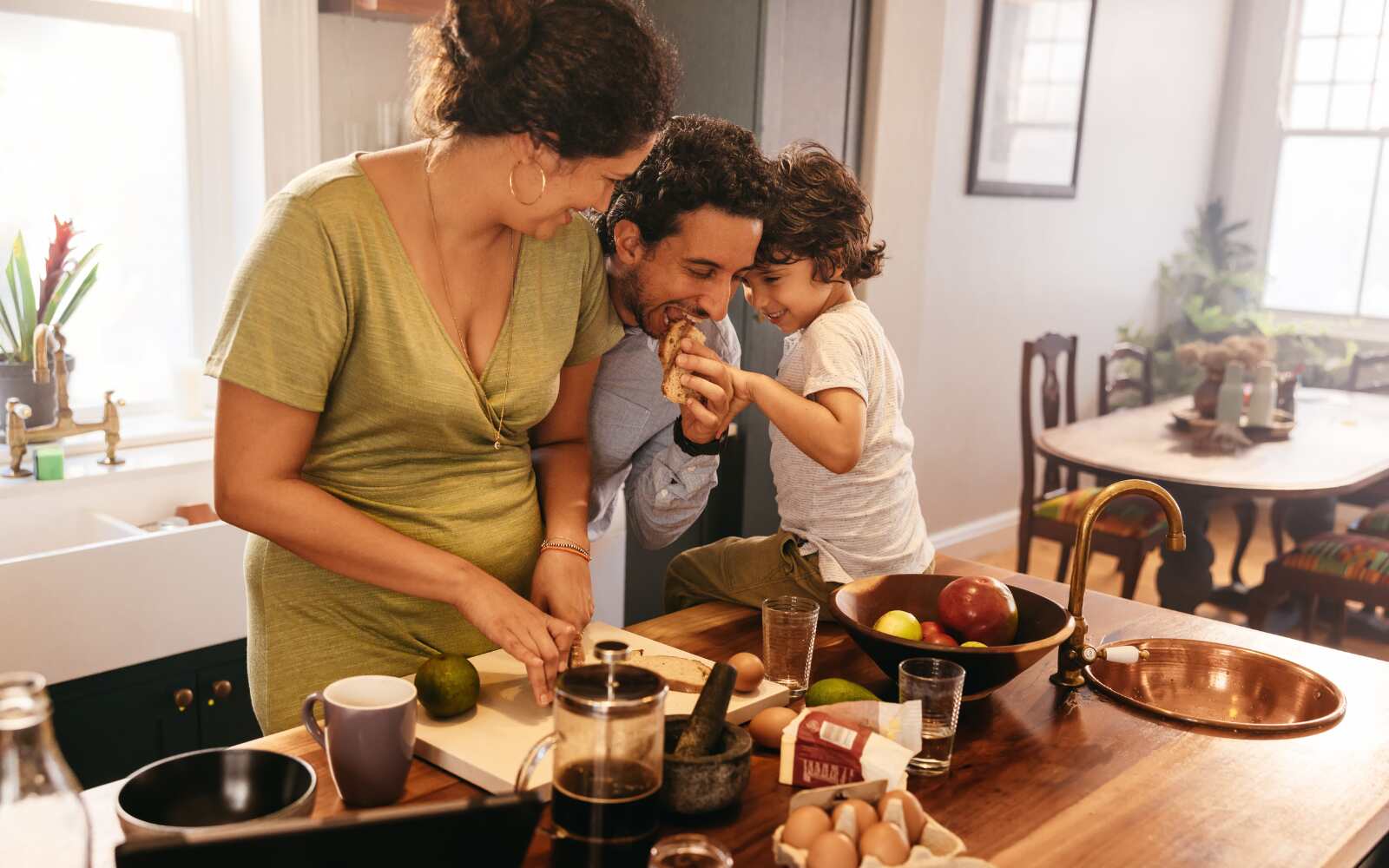 A family is in the kitchen having fun while prepping a meal together