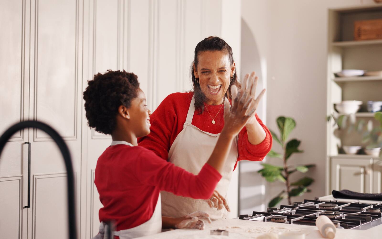 High five, baking and mother with child in kitchen for christmas cookies, dessert or cake together. 